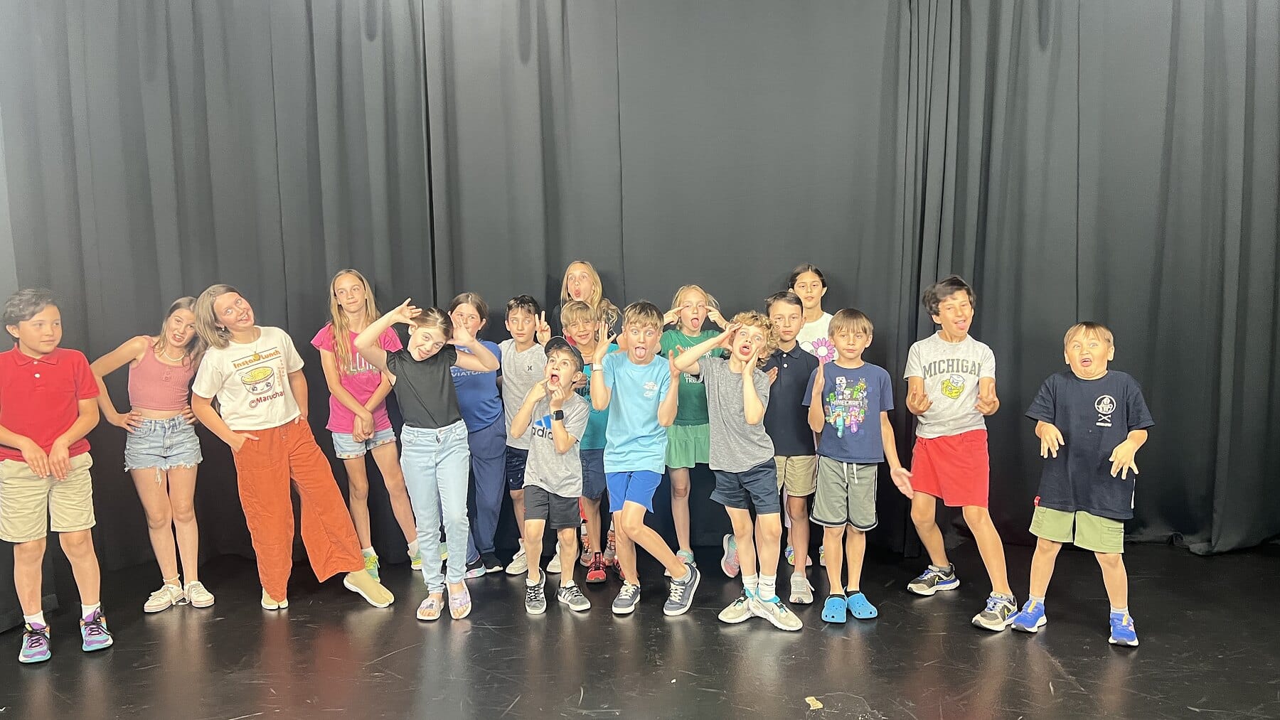 A kid acting class lined up on stage at Dearing Acting Studio in Phoenix