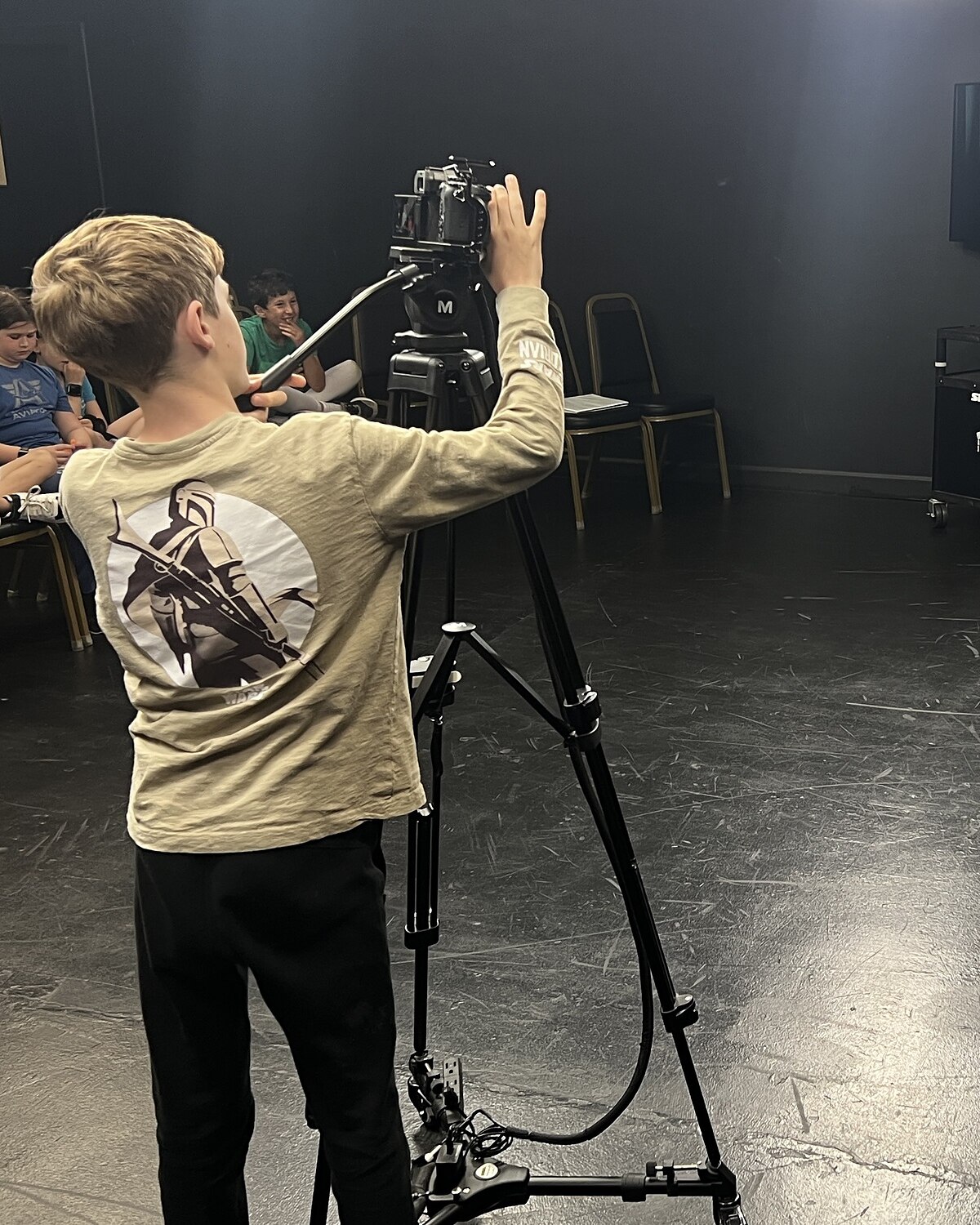 A kid student running one of the four cameras while classmates play a scene at Dearing Acting Studio