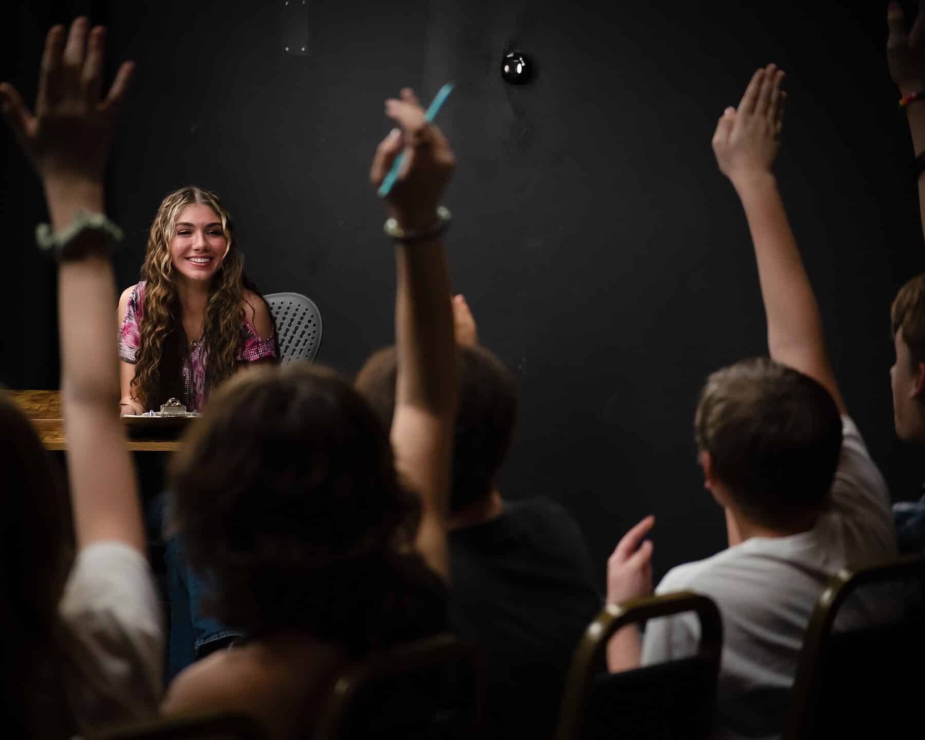Hands up across the room for the next scene in teen improv class at Dearing Acting Studio in Phoenix